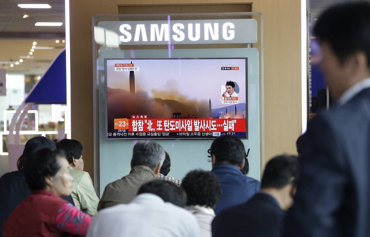 كوريون جنوبيون يتابعون على الهواء لحظات إطلاق كوريا الشمالية إحدى تجاربها الصاروخية قبل أكثر من عام (رويترز)