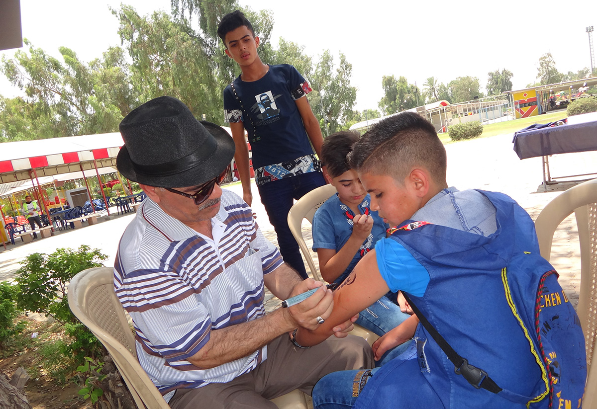 رسام الوشم أبو عراق في حديقة الزوراء في بغداد (اندبندنت عربية)