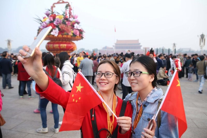 سياح يلتقطون الصور أثناء الاحتفال باليوم الوطني الصيني. (غيتي).jpg