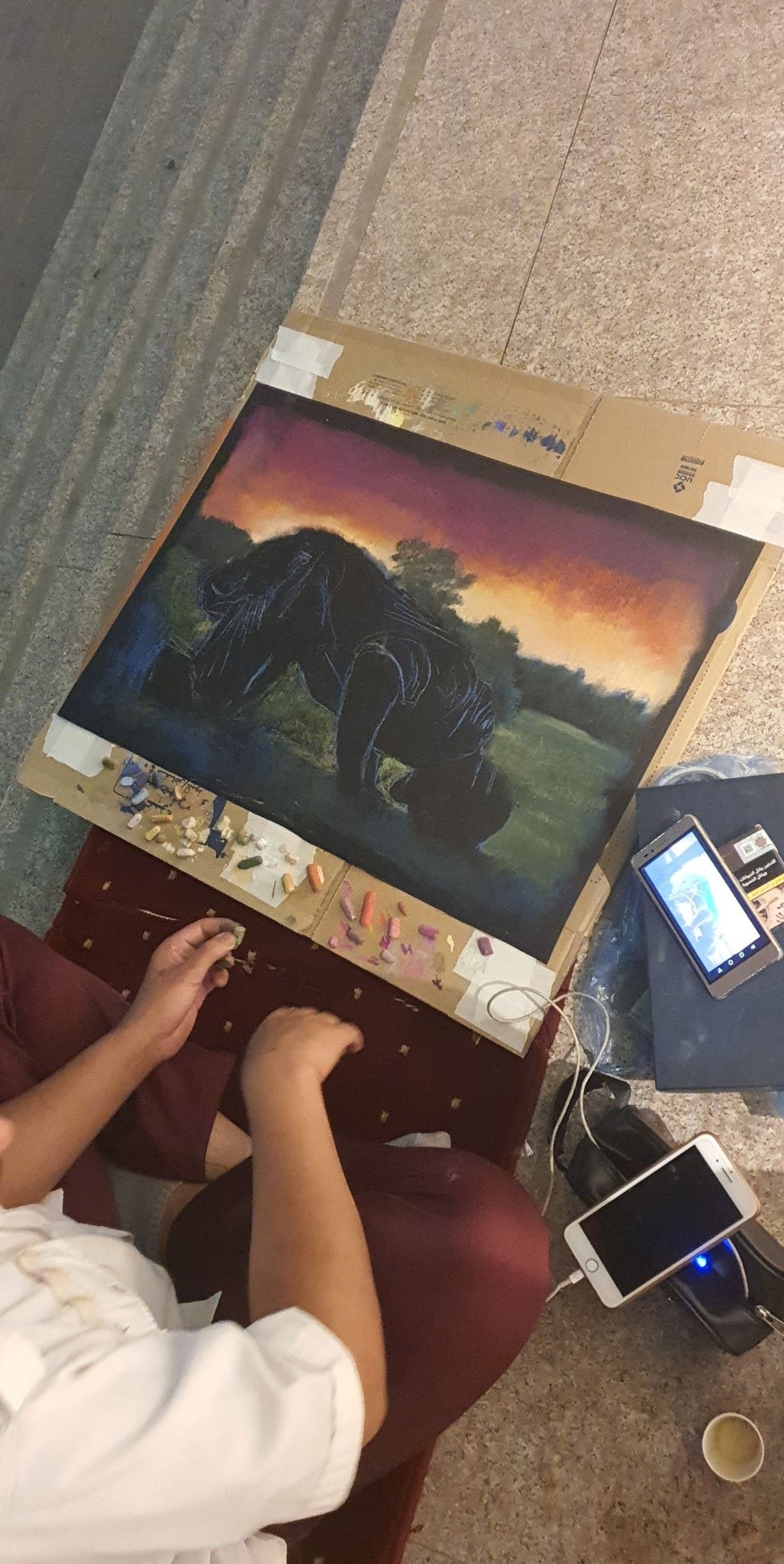 عبدالمحسن يضع اللمسات الأخيرة على لوحته بجوار مقر عمله (تويتر).jpg