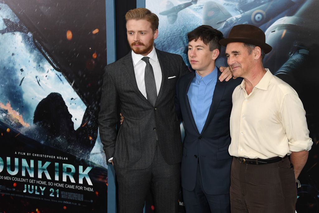 الممثلون في فيلم دانكيرك وخلفهم الملصق الإعلاني للفيلم (غيتي) 
