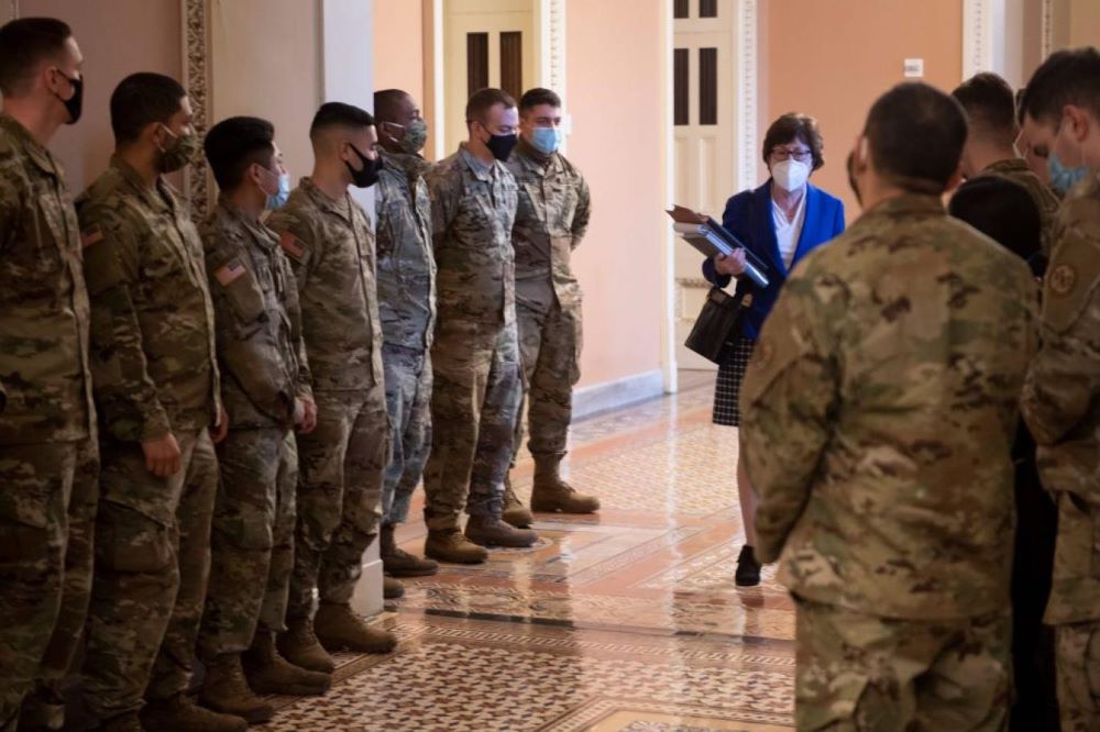 السيناتورة سوزان كولينز تعبر بين جنود الحرس الوطني في طريقها إلى جلسة محاكمة ترمب (أ.ف.ب).jpg