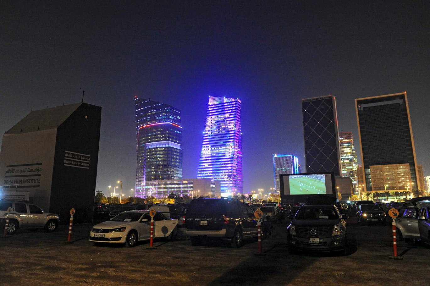 مشجعون يتابعون مباراة لكرة القدم في الهواء الطلق في الدوحة (أ ف ب وغيتي)