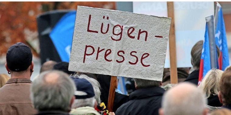 thumbnail_متظاهرون في ألمانيا يحملون لافتة مكتوب عليها صحافة كاذبة.jpg
