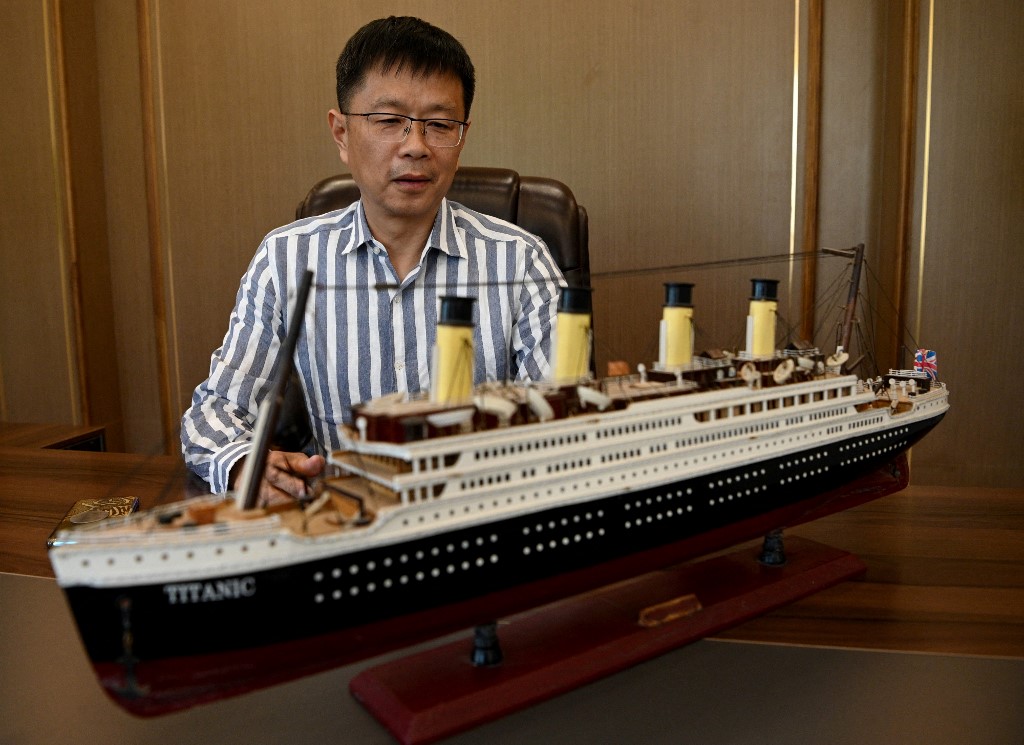 صاحب الفكرة سو شاوجون مع مجسم لسفينة "تيتانيك" (أ ف ب)