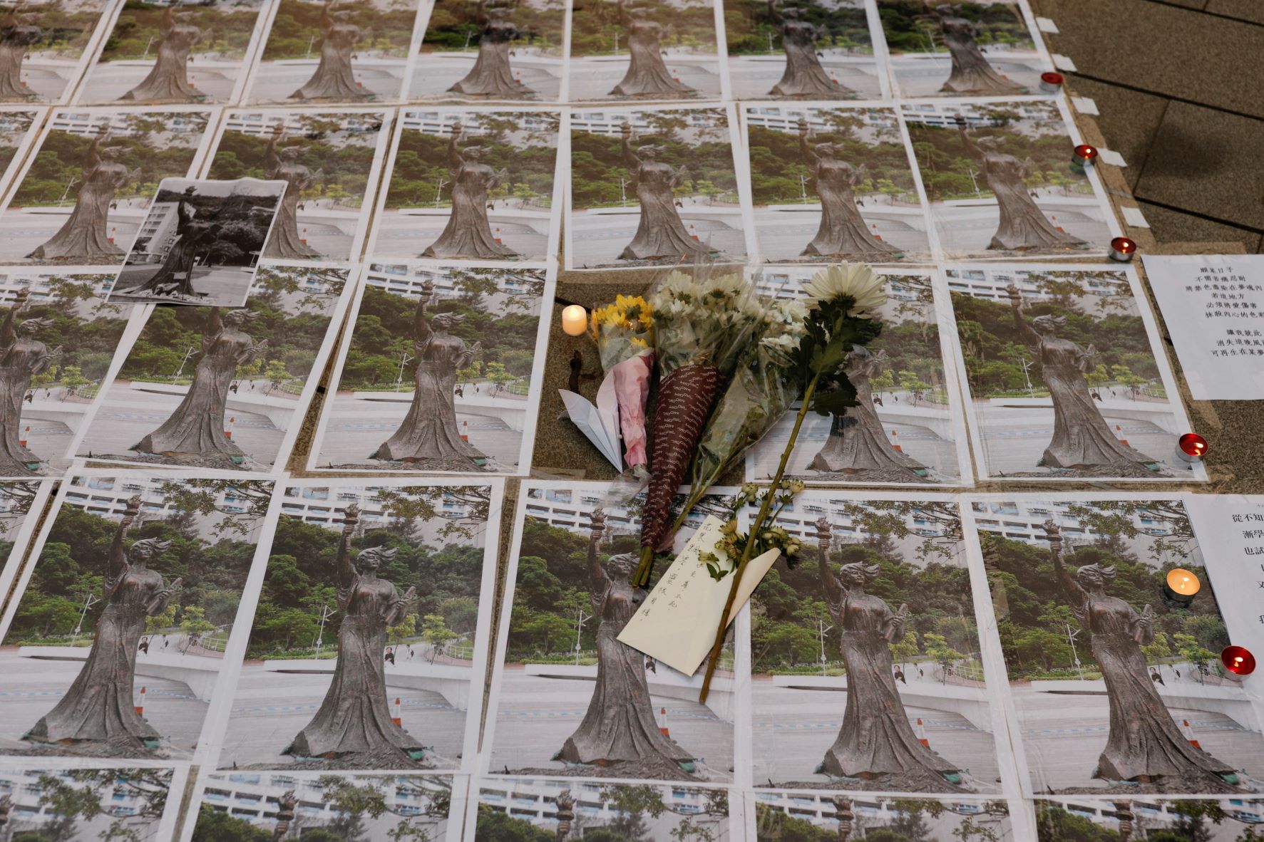 زهور وكتابات وصور لـ"إلهة الحرية" في مكان تمثالها الذي أزالته إدارة "جامعة الصين في هونغ كونغ" أخيراً 