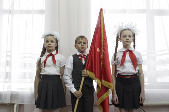 أطفال يرتدون مناديل عنق حمراء تُعتبر رمز "منظمة الطلائع"، يحضرون حفل تنصيب أعضاء جدد في مدرسة في منطقة "ستافروبول"، روسيا، نوفمبر (تشرين الثاني) 2015.