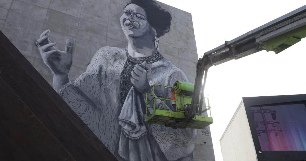 نورة بن سعيدان أثناء رسمها لجدارية أم كلثوم في البوليفارد (رويترز)