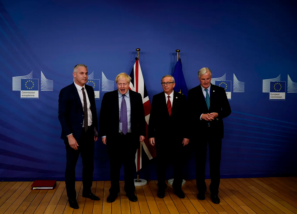 بوريس جونسون مع جان كلود يونكر وبارنييه (الثاني من اليمين، والأول من اليمين على التوالي) ووزير "بريكست" البريطاني ستيفن باركلي (يسار الصورة) في مؤتمر صحافي في بروكسل سنة 2019 