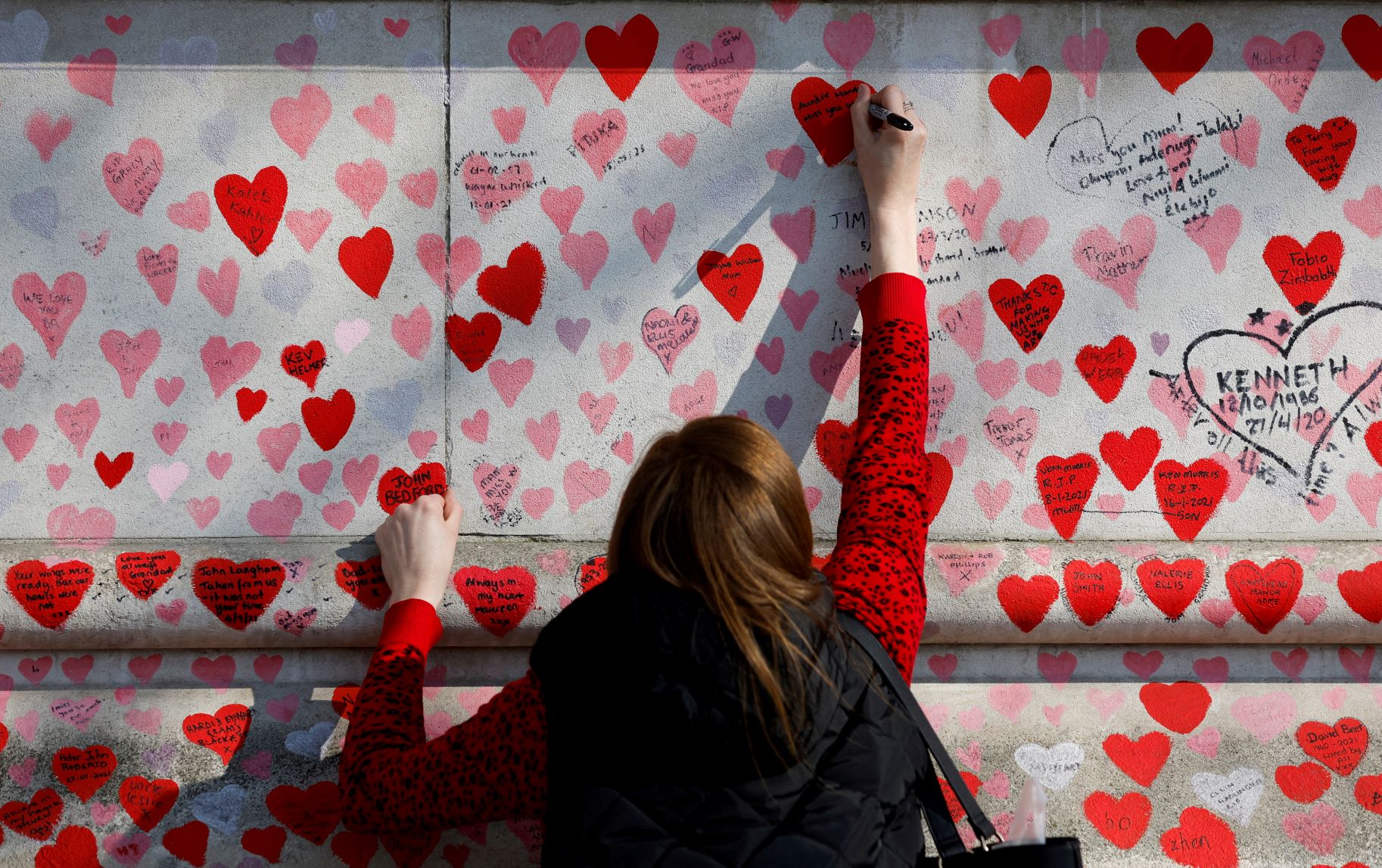 تدوين رسالة على "الجدار الذكرى الوطنية لكوفيد" في لندن، بالتزامن مع الذكرى الثانية لأول إغلاقات كورونا في المملكة المتحدة