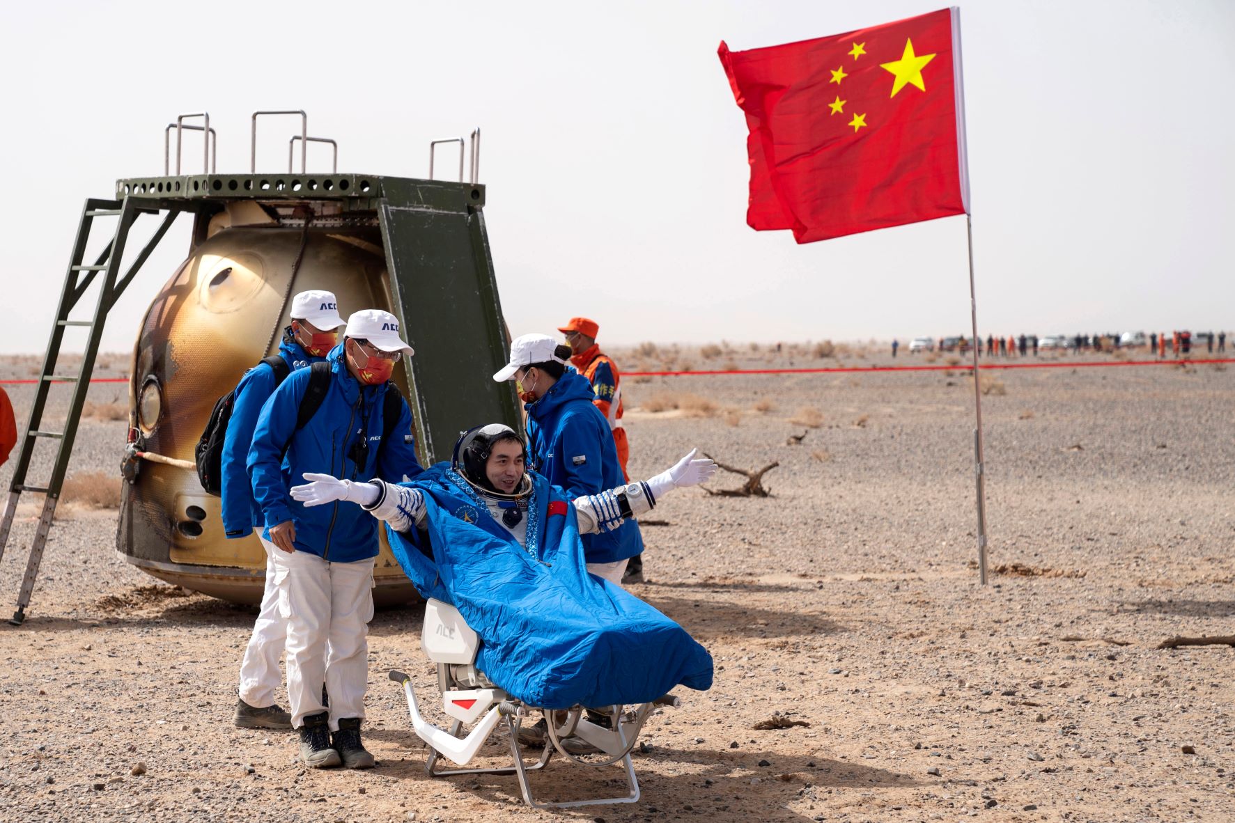 رائد الفضاء الصيني يي غوانغ فو جالساً على كرسي خارج كبسولة العودة من المركبة "شِنزهو- 13" عقب مهمة فضائية مأهولة. حطت الكبسولة في موقع هبوط في منشوريا الصينية