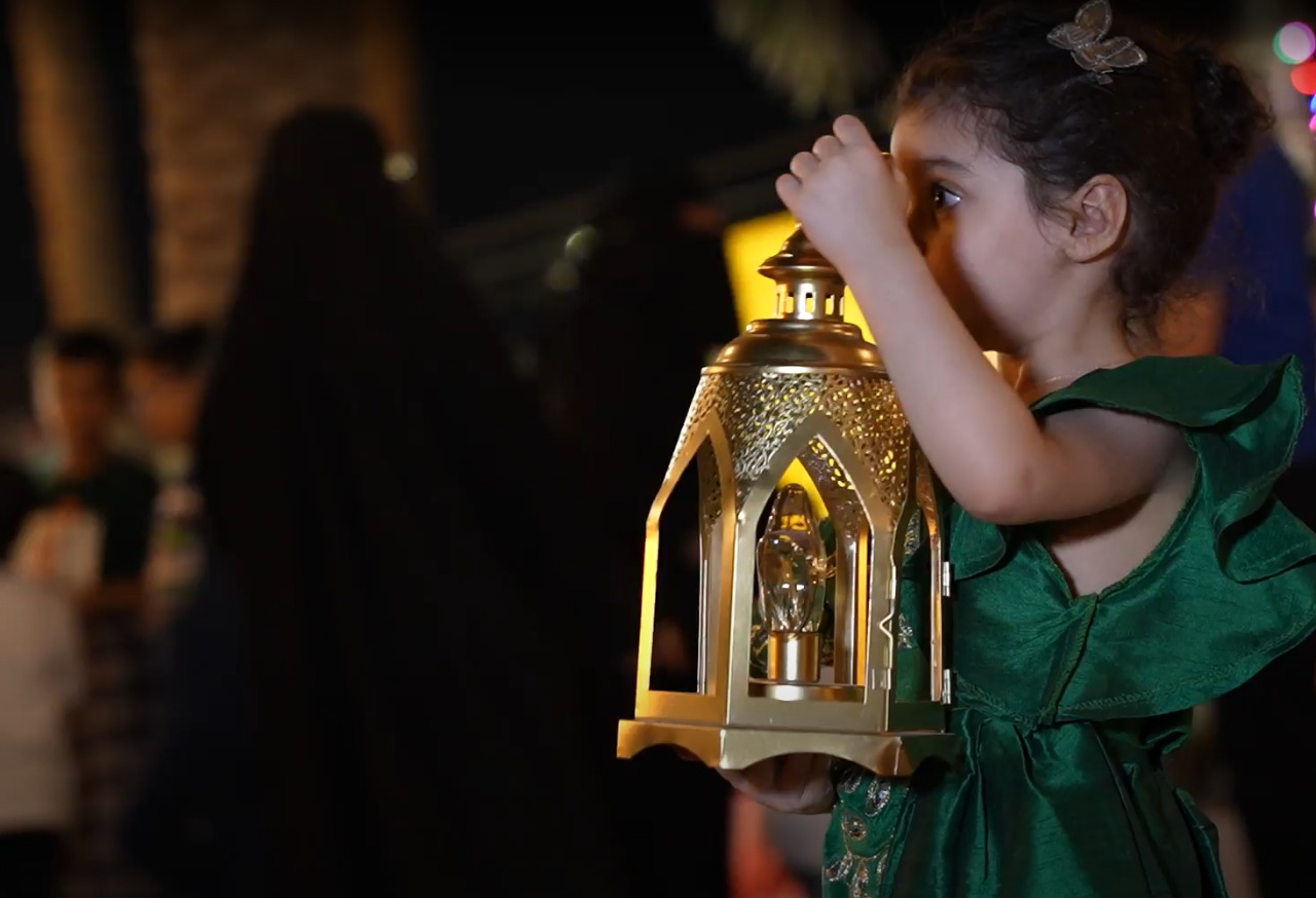 طفلة تحمل فانوس أثناء تجولها في تاروت (اندبندنت عربية)