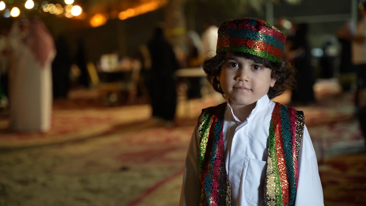 طفل بأزياء شعبية ملونة كما جرت العادة في مناسبات القرقيعان سنوياً (اندبندنت عربية)