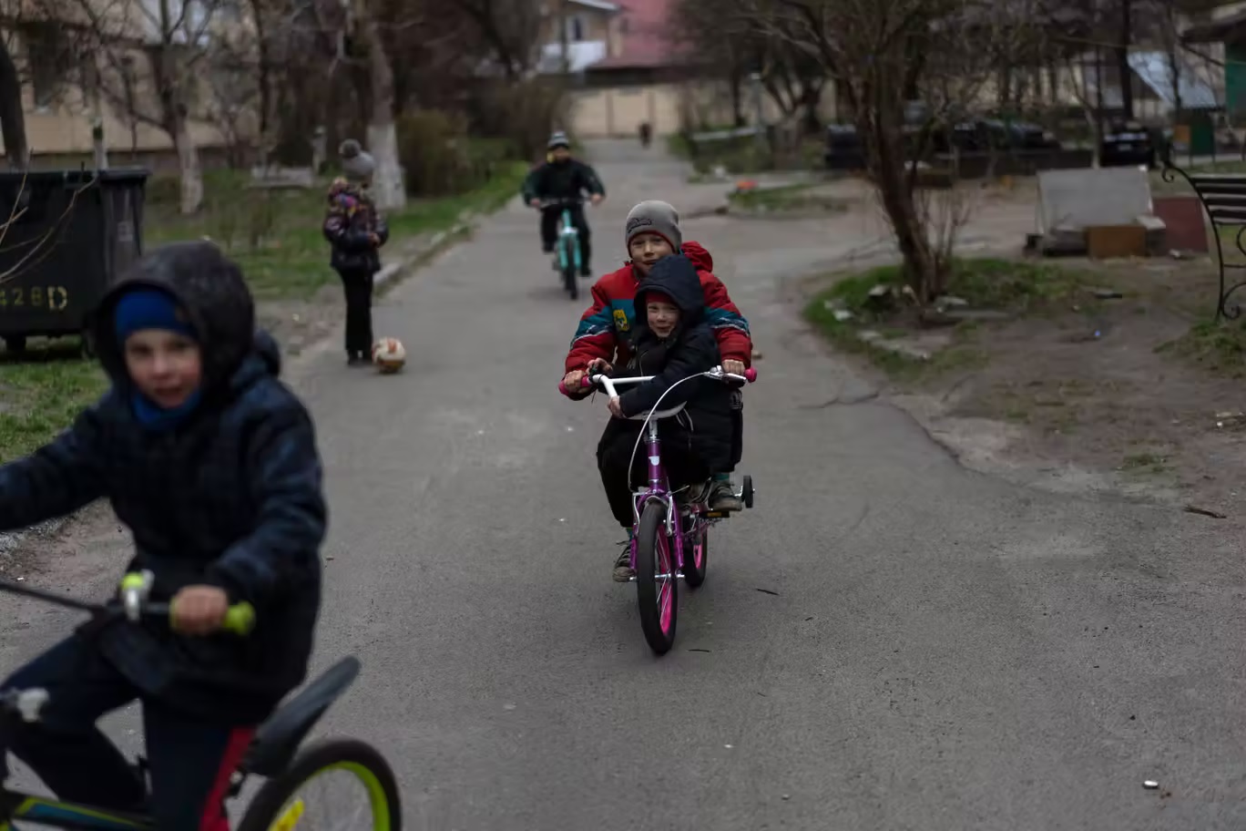 أطفال يلعبون في بوتشا بضواحي كييف، أحد المواقع العديدة التي يشتبه في قيام الجيش الروسي بارتكاب جرائم حرب فيها (أ ب)