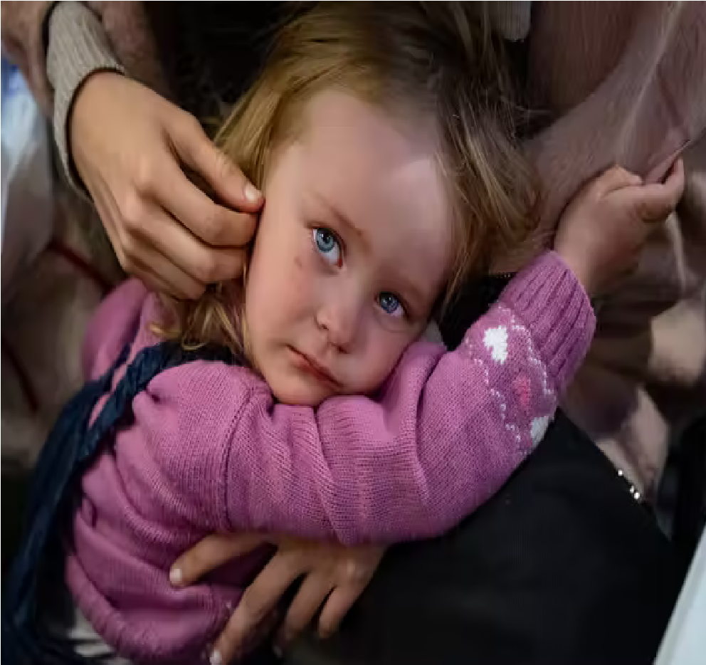 Paulina, who is just over 2 years old, is comforted by her sister after fleeing Mariupol (Bel Trew).png