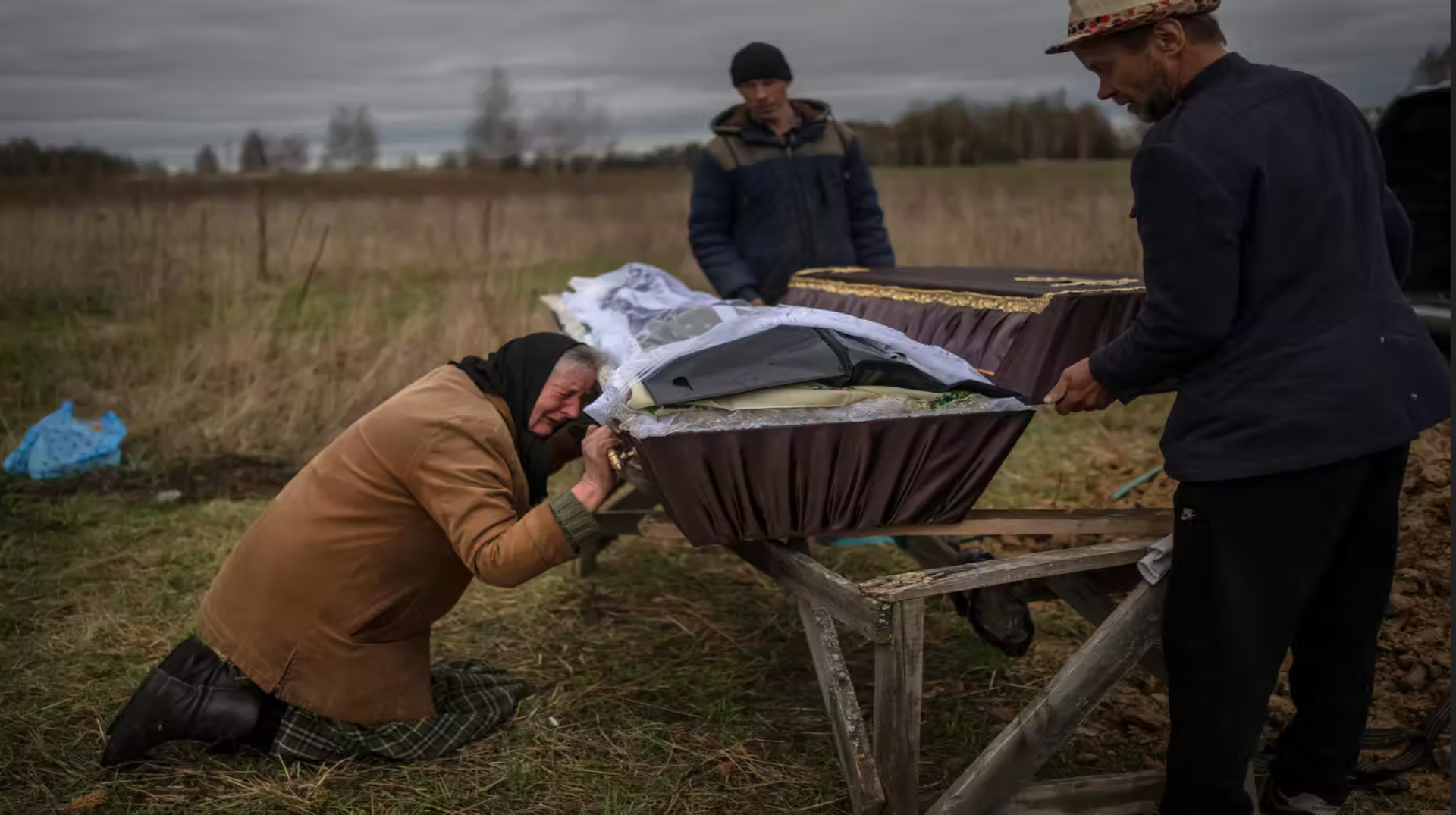  امرأة تبكي أثناء الإمساك بنعش ابنها فاديم (48 عاماً) الذي قتله جنود روس في بوتشا