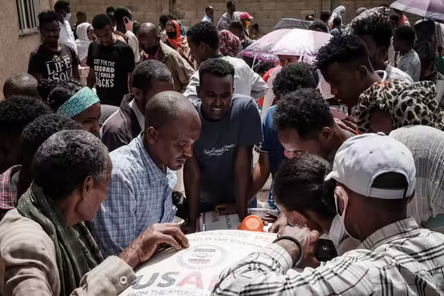 People who fled violence in Ethiopia’s Tigray region gather to receive aid in Mekele in June 2021.png