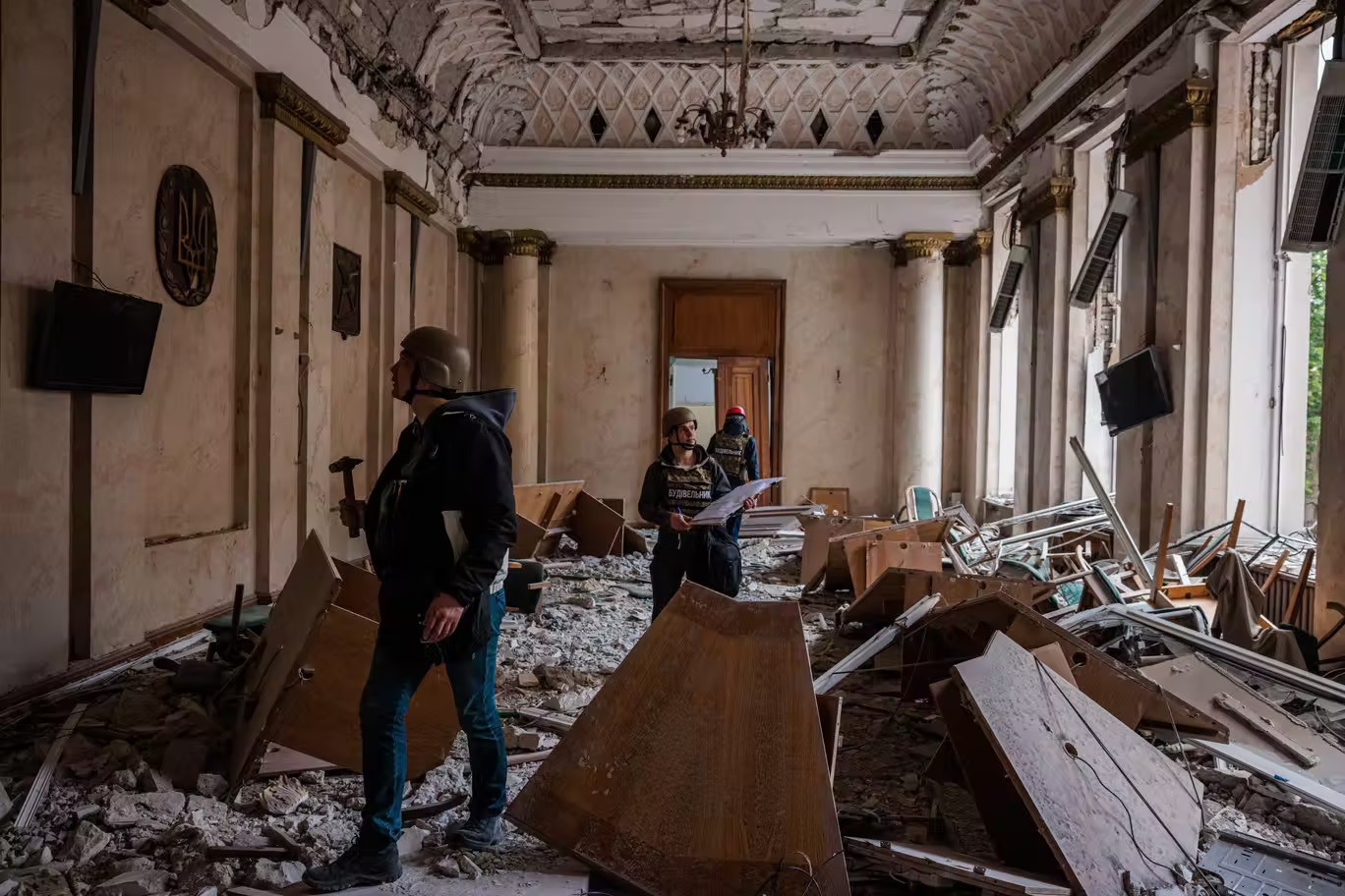 مهندسون يتفقدون مبنى رسميا متضررا في خاركيف بعد قصفه من قبل القوات الروسية (أ ف ب عبر غيتي)