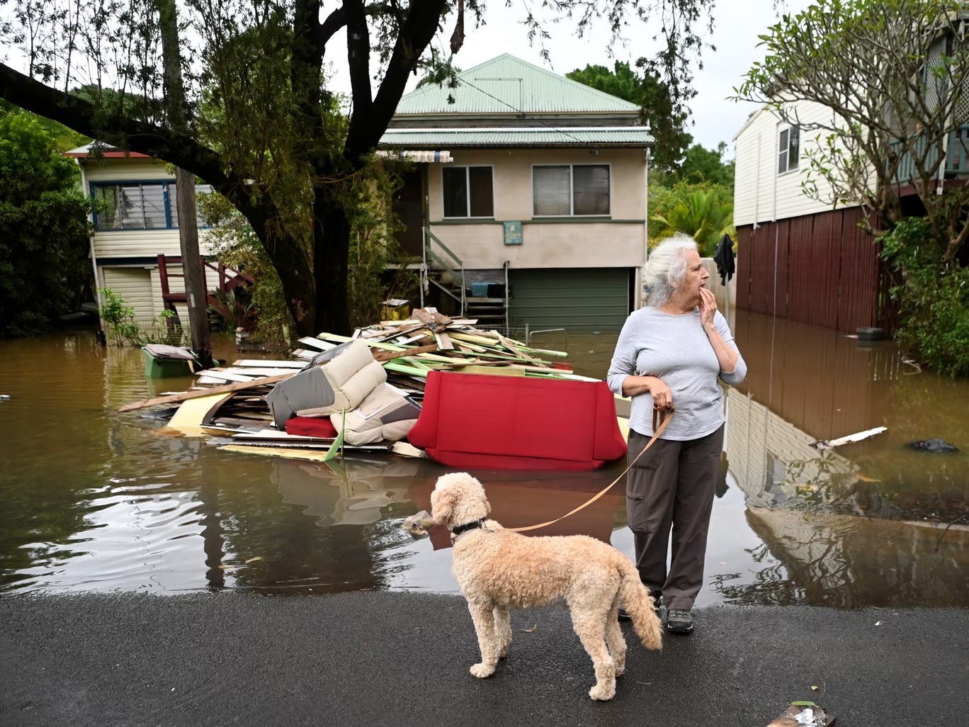 كاثي جوردان تتفقد شارعها في ليسمور (أستراليا) بعد أن غمرته مياه الفيضانات في مارس (غيتي)