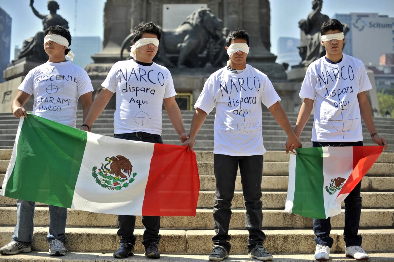 أعضاء منظمة اجتماعية يحملون الأعلام المكسيكية الوطنية أثناء احتجاجهم على عنف عصابات المخدرات في سيوداد خواريز (أ ف ب/غيتي)