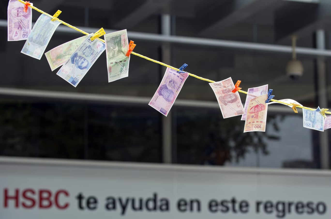 أوراق نقدية مزيفة منشورة تحت الشمس "لتجف" أثناء احتجاج أمام مبنى فرع "HSBC"  في مكسيكو سيتي (أ ف ب/غيتي)