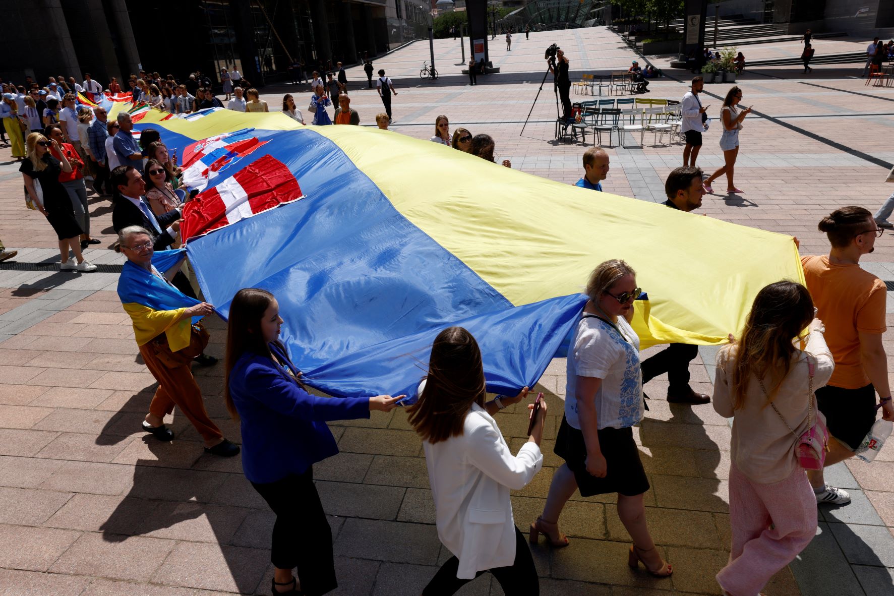 أوكرانيون ومشرعون أوروبيون يبسطون علم لأوكرانيا طوله 30 متر أمام مقر البرلمان الأوروبي لحثه على تأييد انضمام كييف للكتلة الأوروبية 