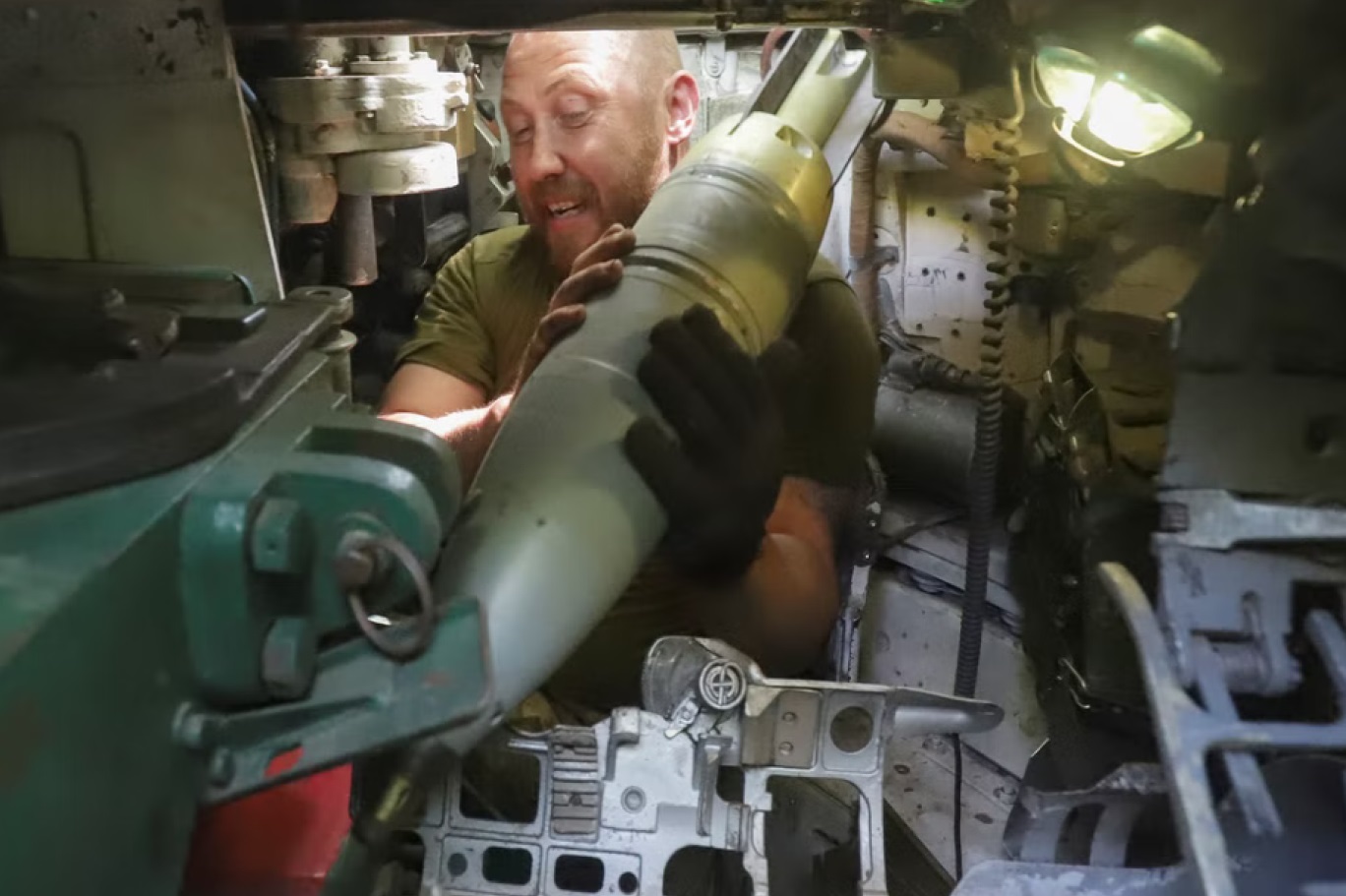 جندي أوكراني يضع قذيفة في مدفع دبابة تشارك في القتال في شرق أوكرانيا (رويترز)