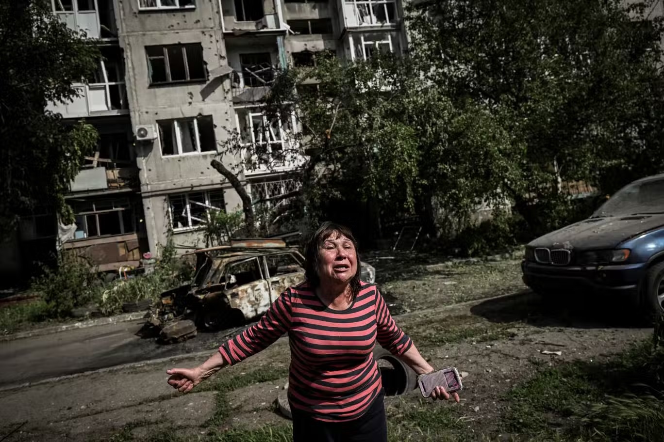 امرأة منفعلة بعد هجوم صاروخي بالقرب من مبنى سكني في مدينة سلوفيانسك (أ ف ب/غيتي)