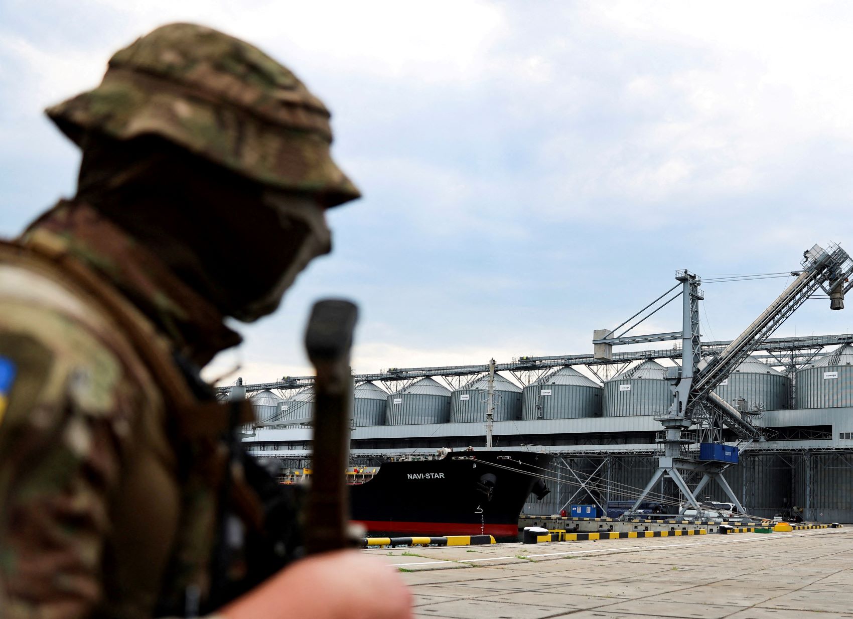 جندي أوكراني أمام إهراء للقمح في ميناء أوديسا على البحر الأسود بانتظار إشارة من الأمم المتحدة وتركيا لإبحار أول باخرة تحمل الحبوب إلى الخارج وسط الحرب مع روسيا بتاريخ 29 يوليو 2022