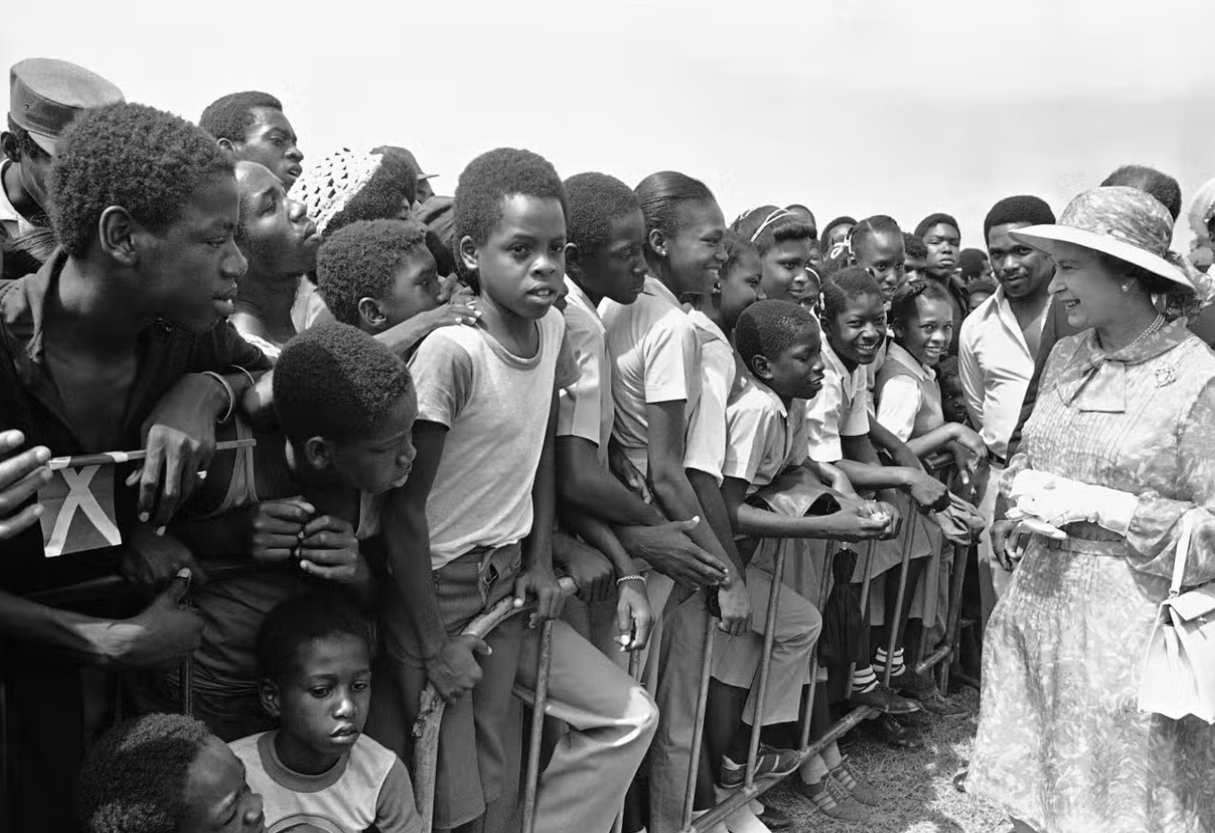 طلبة مدارس جامايكيين يحييون الملكة إليزابيث الثانية في كينغستون سنة 1983 