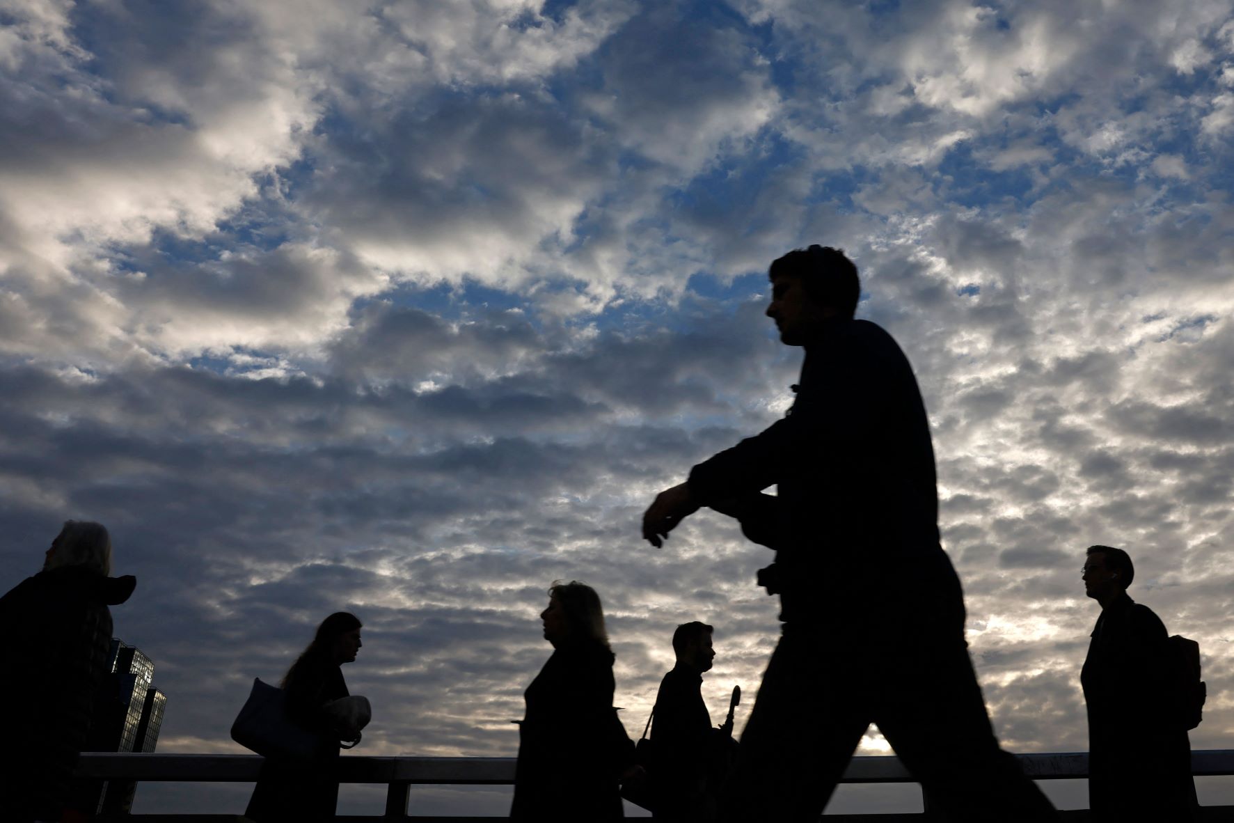 مشاة يعبرون فوق جسر لندن أثناء ذهابهم إلى أعمالهم في وسط المدينة بتاريخ 12 أكتوبر 2022 