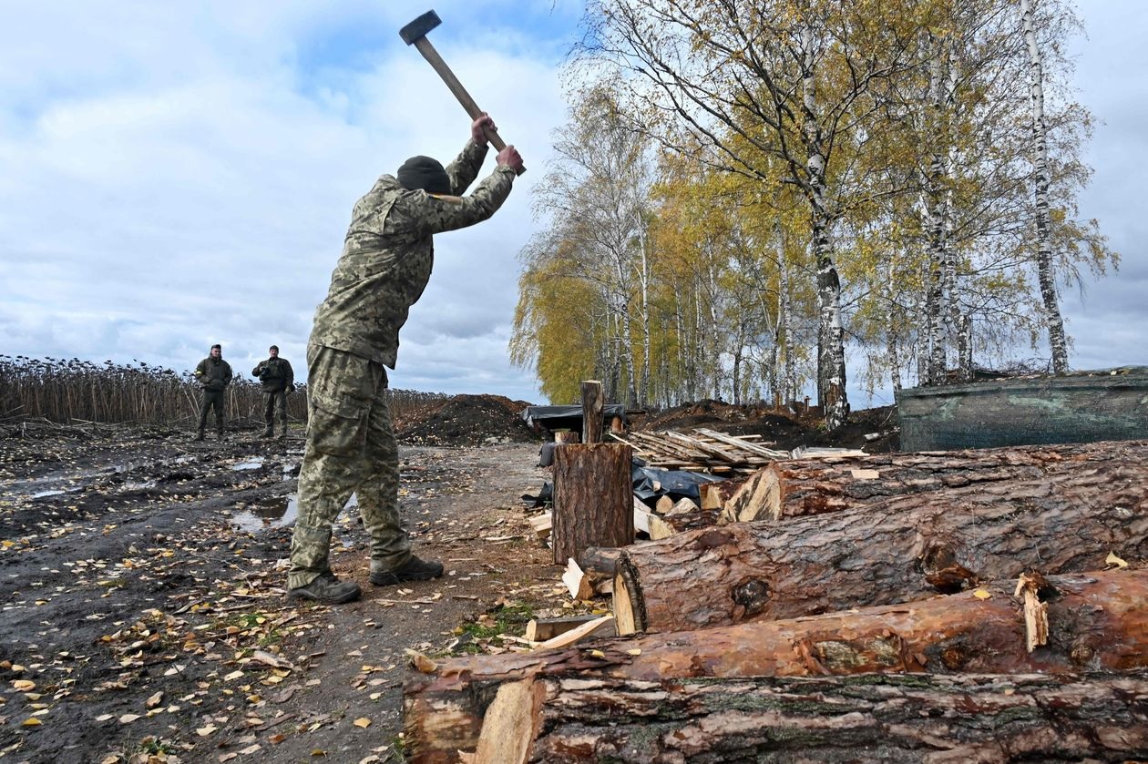 جندي من الحرس الوطني الأوكراني يقوم بتجهيز الحطب في منطقة خاركيف (أ ف ب/غيتي)