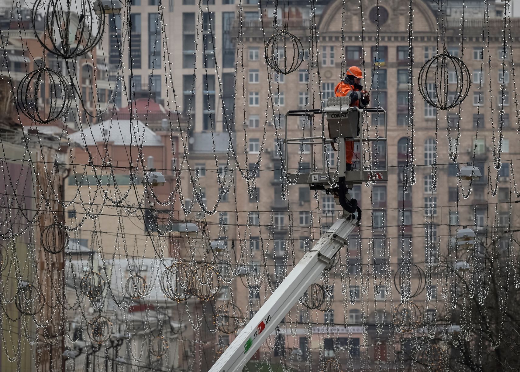 عامل يعلق أضواء الزينة في وسط كييف ضمن الاستعدادات لاحتفالات عيدي الميلاد ورأس السنة المقبلين، بتاريخ 15 نوفمبر 2022 