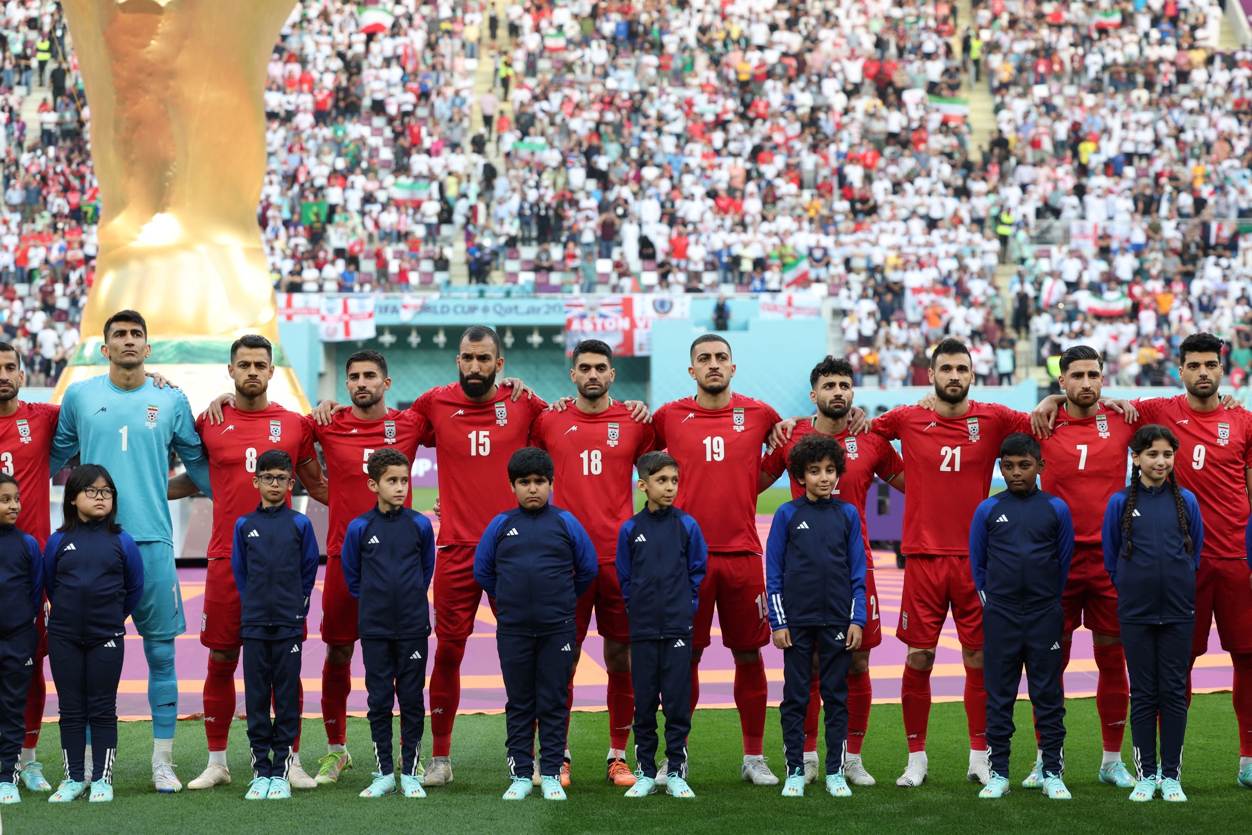 لاعبو المنتخب الايراني يستمعون إلى النشيد الوطني (أ ف ب)