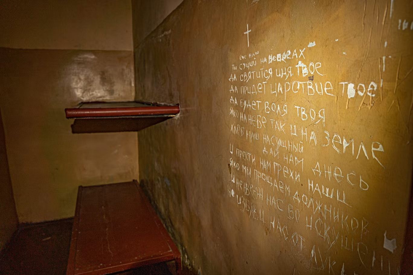 كلمات الصلاة الربانية المسيحية محفورة على جدار زنزانة أولكسندر الصغيرة حيث تم احتجازه وتعذيبه على مدى أسابيع في بالاكليا (بيل ترو)