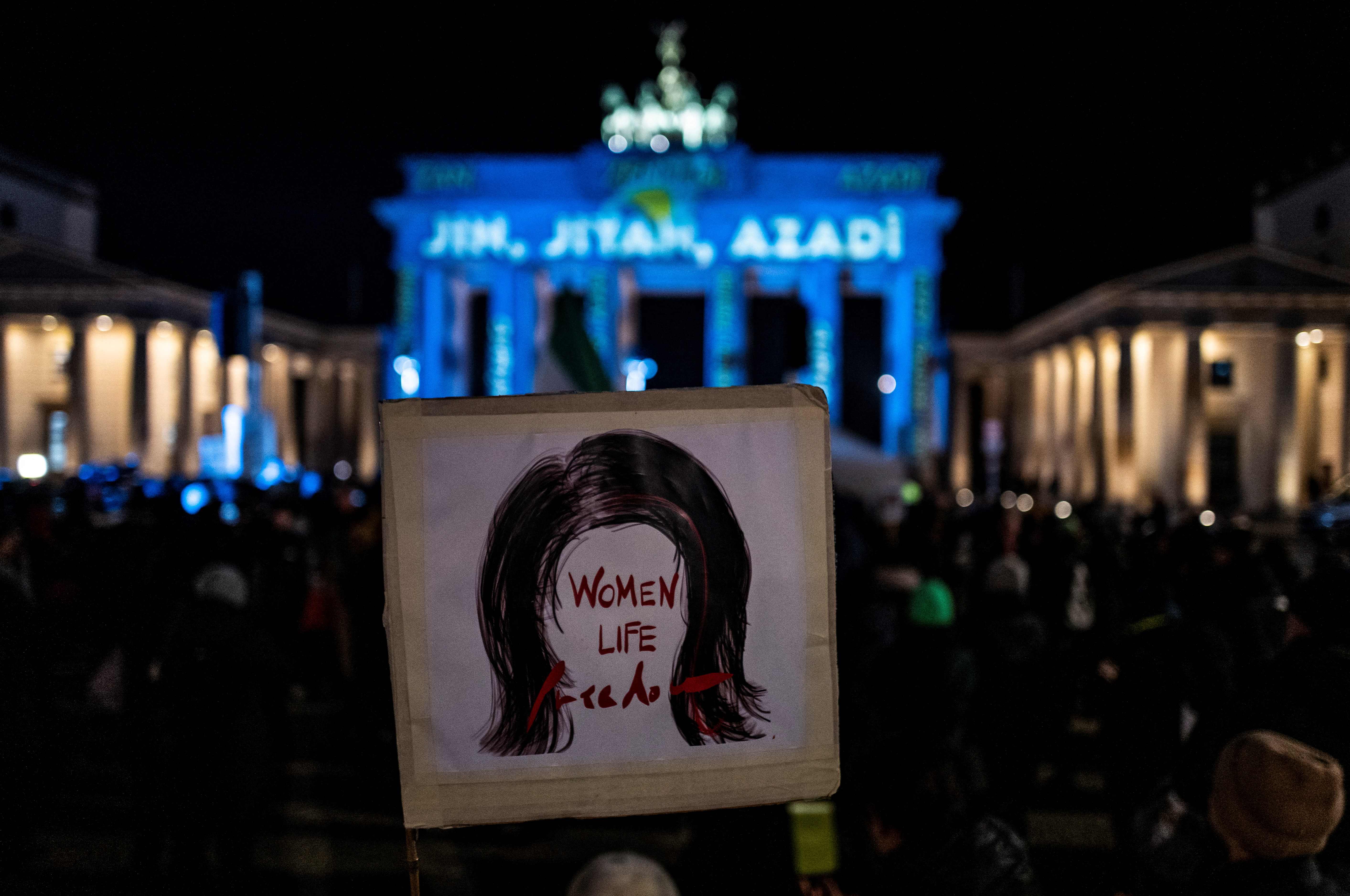 يافطة رفعت خلال تظاهرات مؤيدة للاحتجاجات في إيران وقد كتب عليها "نساء، حياة، حرية" قرب بوابة براندنبورغ في برلين بتاريخ 13 ديسمبر 2022 