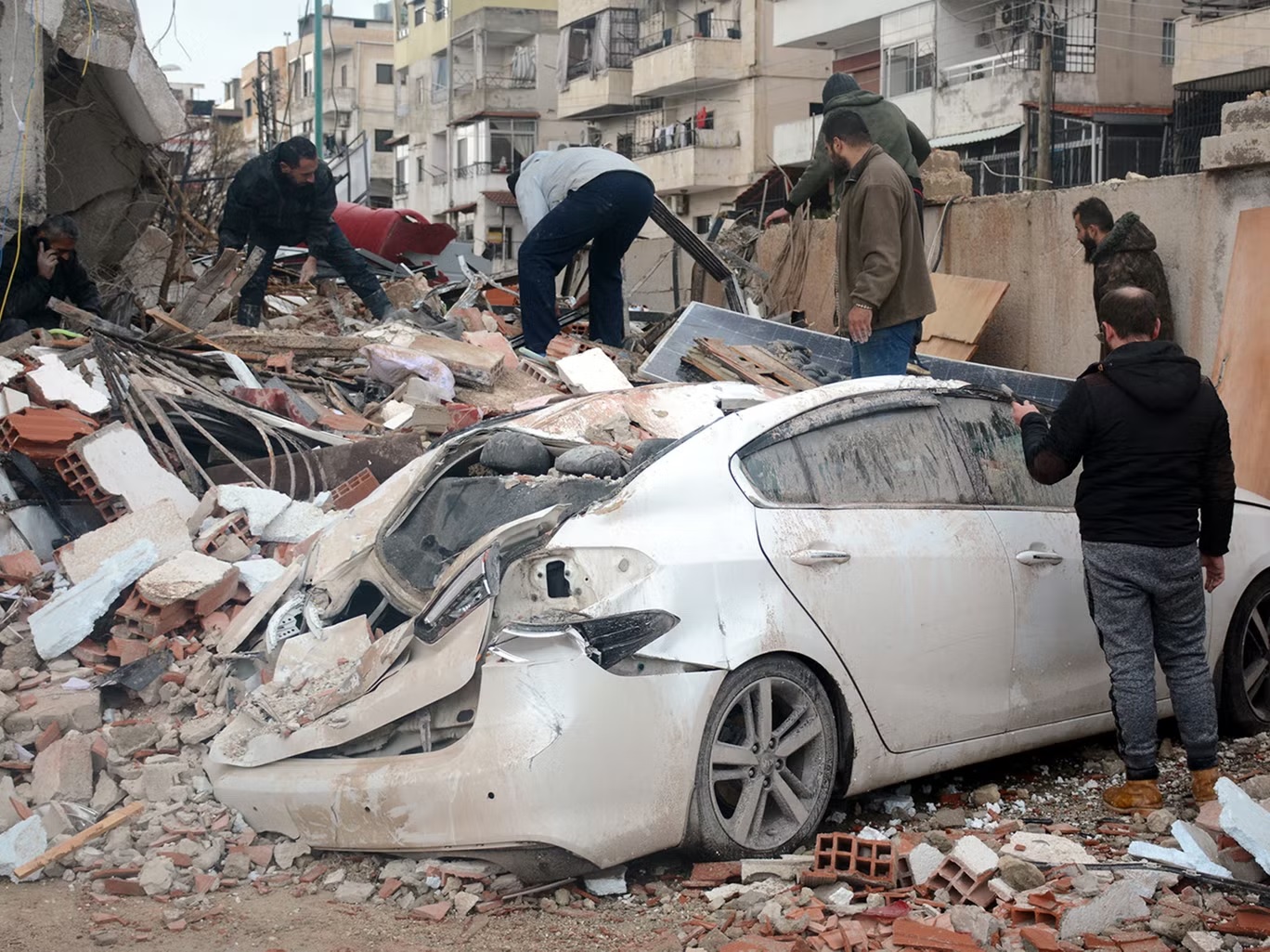 رجال الإنقاذ يبحثون عن ناجين في موقع مبنى منهار بعد الزلزال الذي ضرب اللاذقية في سوريا (رويترز) 
