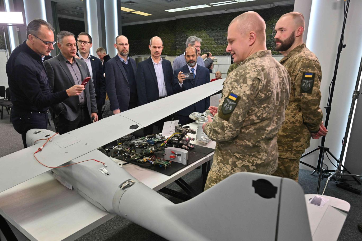 خبراء عسكريون أوكرانيون يستعرضون طائرة مسيرة يزعم أن روسيا استخدمتها لضرب أهداف في أوكرانيا (أ.ف.ب)