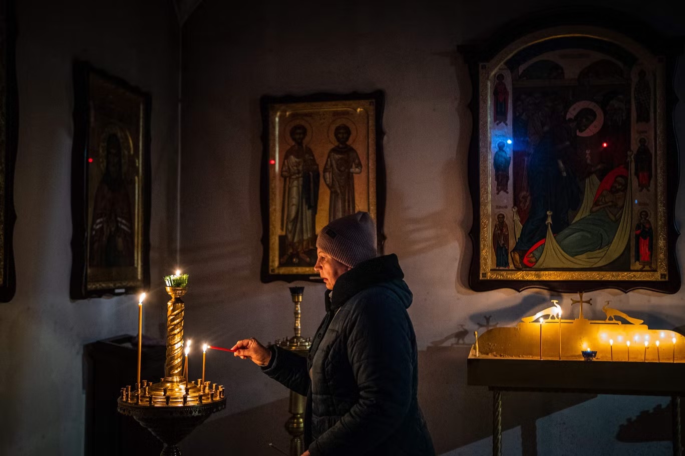 امرأة تضيء شمعة في كنيسة القديس أندرو في بوشا بالقرب من كييف يوم الجمعة (أ ف ب عبر غيتي)