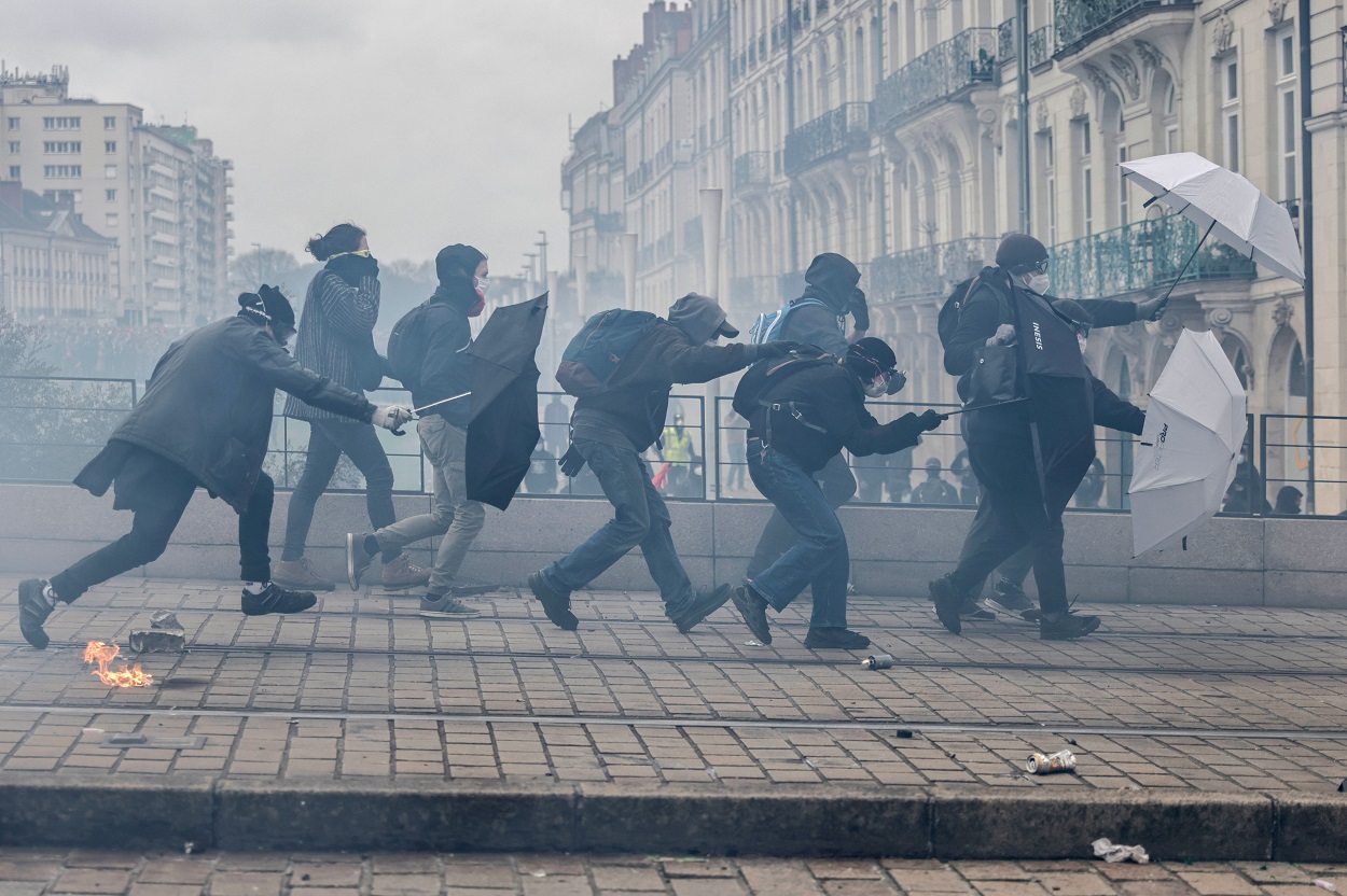 Protesters with umbrellas scuffle with riot police during a rally in Nantes on Thursday_AP.jpg