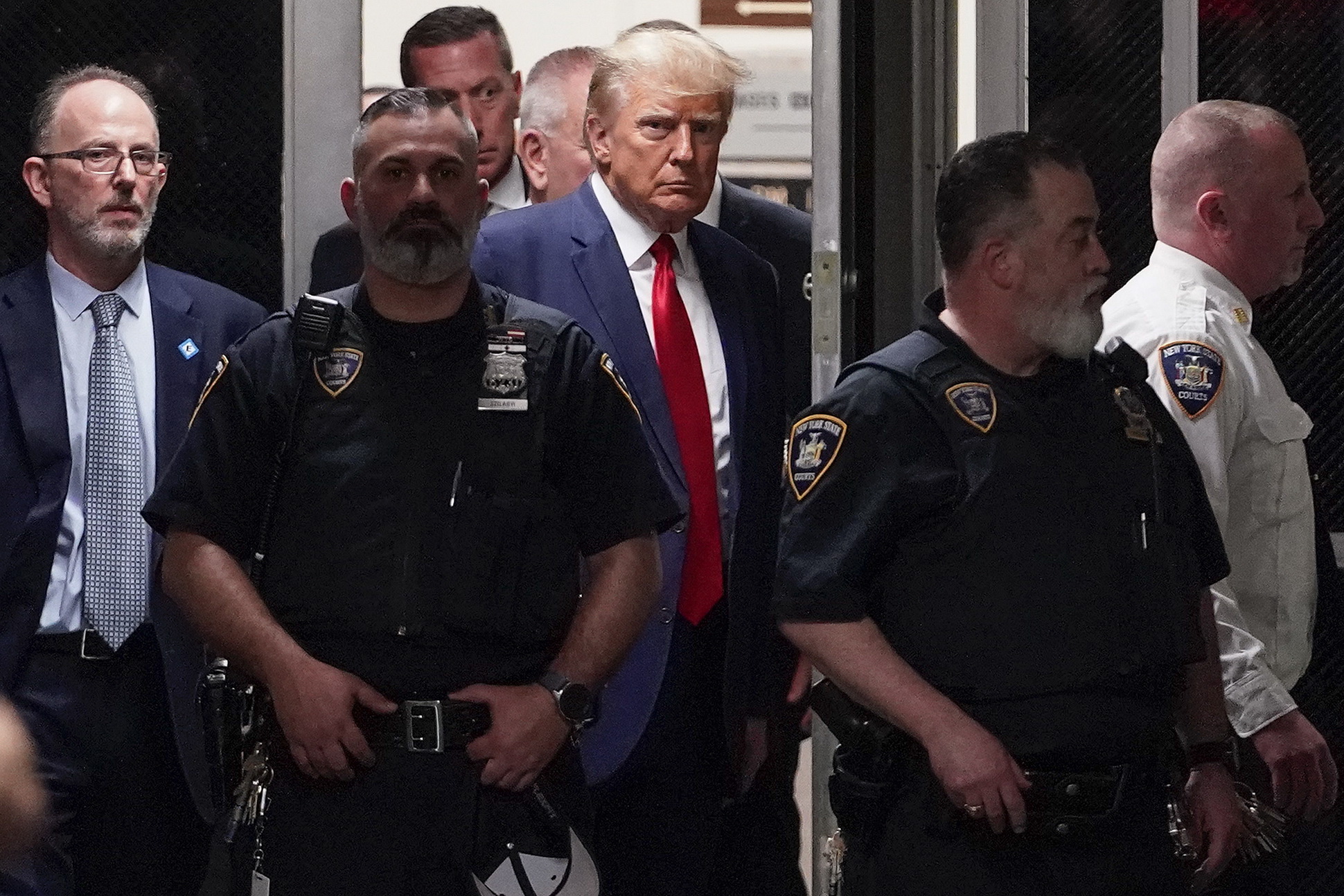 الرئيس الأميركي السابق دونالد ترمب يدخل قاعة المحكمة مع مرافقيه في نيويورك بتاريخ 04 إبريل 2023 
