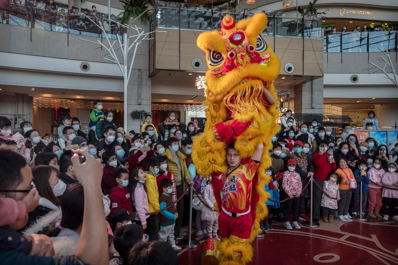 راقصون بزي أسد يقدمون عرضاً أمام الجمهور خلال احتفالات السنة القمرية الصينية الجديدة والربيع داخل مركز تسوق في 26 يناير (غيتي)