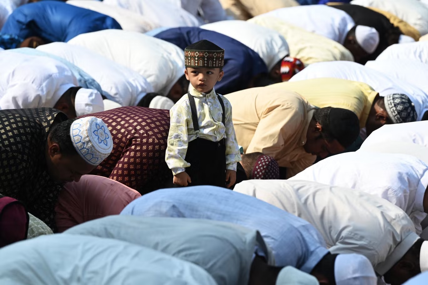 صبي يقف وسط جمع من المصلين المسلمين خلال صلاة عيد الفطر، قبل انطلاق احتفالات العيد في حيدر آباد يوم 22 أبريل (أ ف ب/ غيتي)