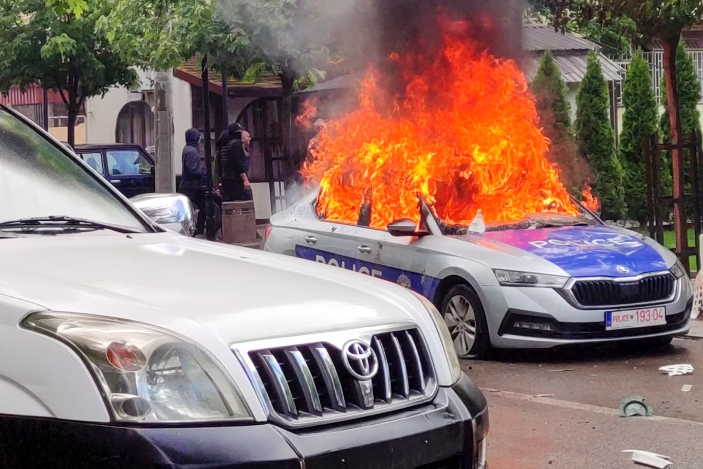 سيارة شرطة تحترق في زفيكان، شمال كوسوفو، في الـ26 من مايو (أ ب)