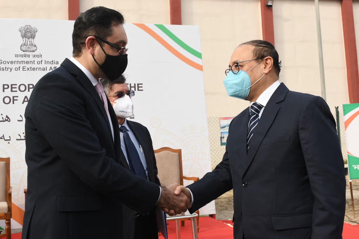وزير الخارجية الهندي هارش فاردان شرينغلا (يمين) والسفير الأفغاني لدى الهند فريد ماموندزاي يتصافحان في فبراير 2022 (أ ف ب / غيتي)