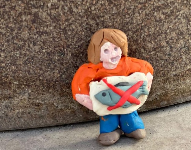 شخصية طينية تحمل رمز "لا للسمك" ومغزاها "لا للحرب" (إنستغرام "مالينكي بيكيت")