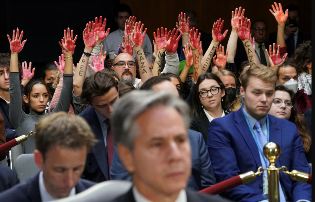 متظاهرون مناهضون للحرب يرفعون أياديهم "الدامية" خلف وزير الخارجية الأميركي أنتوني بلينكن خلال جلسة استماع حول طلب المساعدات الإضافية بقيمة 105 مليارات دولار لدعم إسرائيل وأوكرانيا 