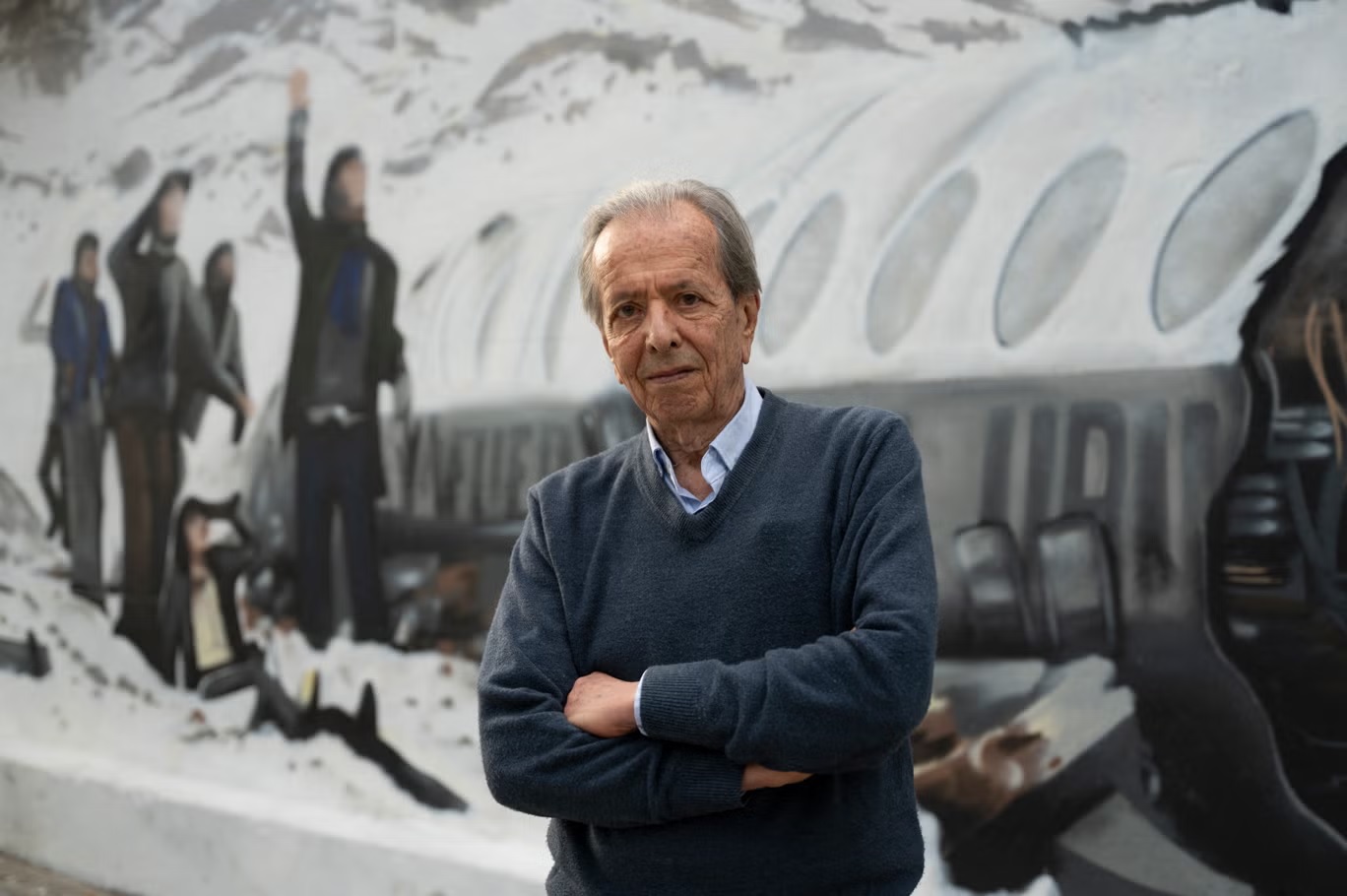 دانييل فرنانديز، أحد الناجين الـ16 من حادثة تحطم طائرة عام 1972، يقف أمام لوحة جدارية تصور الحادثة في مونتيفيديو في نوفمبر 2023 (أ ف ب عبر غيتي)
