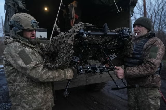 جنود أوكرانيون يقومون بتفريغ طائرة قتالية من دون طيار من طراز "مصاص دماء" بالقرب من باخموت (رويترز)