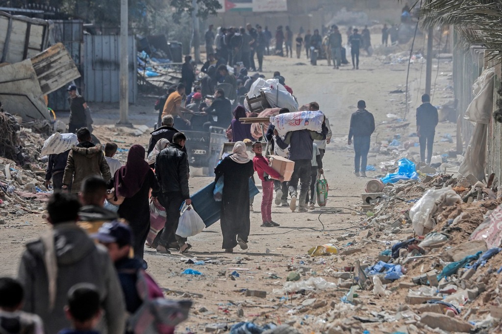 نازحون فلسطينيون يحملون ممتلكاتهم عبر أحد شوارع خان يونس جنوب قطاع غزة في 6 مارس 2024 (أ ف ب).jpg